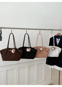 Detailed macro view of four plush lamb wool tote bags in earthy tones with bear charms