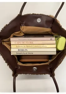 Spacious interior of dark brown faux shearling tote bag showing storage for books and umbrella