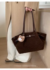 Detail of plush coffee tote bag with leather straps and cute teddy bear charm