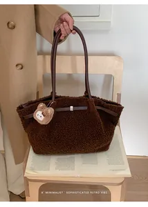 Detail of plush dark brown faux fur tote bag with leather straps and a bear charm