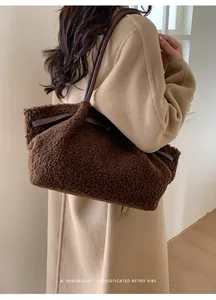 Detail of brown faux shearling tote bag with leather straps on a beige coat