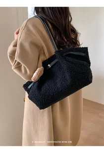 Detail of black faux shearling tote bag with leather strap and cute bear charm pendant
