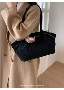 Detail of black fuzzy tote bag with leather handle and brown bear plush charm