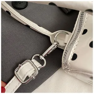 Vista macro de bolso blanco con lunares y herrajes de metal plateado brillante con cremallera