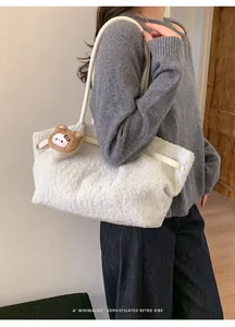 Detail of soft fuzzy tote bag with leather handle and cute brown bear plush charm