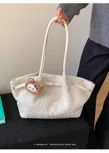 Detail of soft cream faux fur tote bag featuring leather strap and cute bear charm