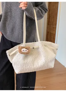 Close-up of white teddy fleece tote bag with brown bear charm and leather strap
