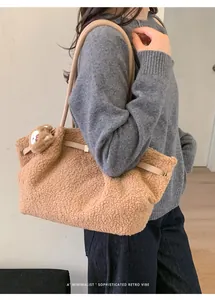 Detail of soft brown plush tote bag featuring a cute bear charm and leather strap