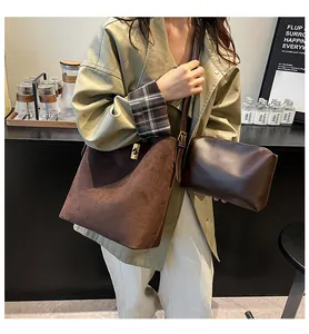 Detail of vintage suede bucket bag with matching inner pouch on model in trench coat