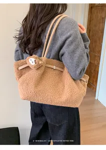 Close-up of camel plush tote bag with leather strap and cute bear charm detail