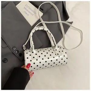 Elegante bolso cilíndrico blanco con lunares negros, asas y correa de bandolera
