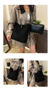 Detail of black suede tote bag with golden square twist lock and matching small pouch