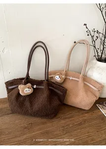 Detail of plush tote bags in dark brown and khaki with cute bear charms on a wooden desk