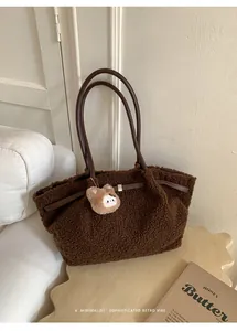 Detail of dark brown plush tote bag with gold lock buckle and cute bear charm pendant