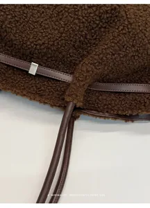 Detail of dark brown plush fleece fabric with leather strap and silver square buckle