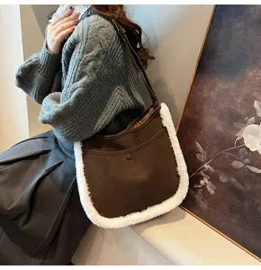Detail of dark brown suede bucket bag with white faux fur trim and adjustable strap