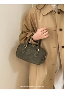Detail of dark olive retro pillow handbag with gold hardware and matte leather texture