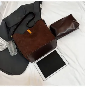 Detail of dark brown suede bucket bag with gold twist lock and matching inner pouch