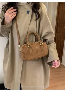 Detail of caramel brown retro pillow bag with top handles and adjustable shoulder strap