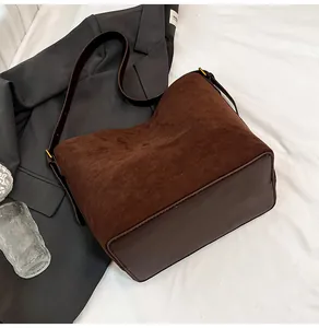 Close-up of deep brown suede bucket bag featuring high-quality leather trim and gold buckle