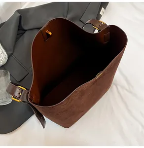 Overhead view showing large capacity and soft suede texture of the brown bucket bag