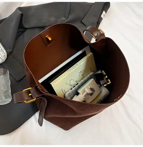 Interior view of brown suede bucket bag showing large capacity and metal buckles