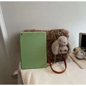 Detailed view of brown faux fur tote bag with golden chain and cute rabbit plush charm