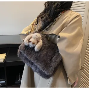 Detail of dark grey faux fur shoulder bag with chain strap and plush rabbit charm