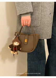 Retro braune Wildleder-Tasche mit Wellendesign, Goldschloss und süßem Plüschbären-Anhänger