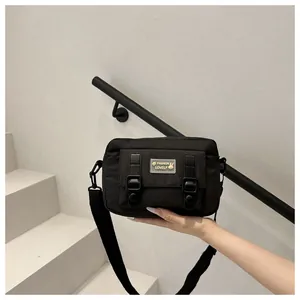 Detail van de zwarte Japanse crossbodytas met dubbele gespen en een stijlvol logo