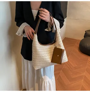 Detail of a beige woven hobo bag with brown leather strap and small square coin purse
