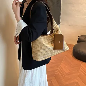 Fashionable beige straw tote bag with brown leather straps and small hanging pouch charm