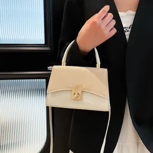 Bolso de mano bicolor para mujer en cuero y paja con cierre dorado en pose elegante