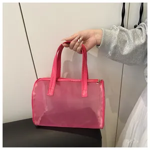 Detail of pink mesh tote bag with smooth faux leather handles and golden metal zipper