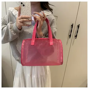 Mirror selfie showing the pink translucent mesh handbag with leather handles