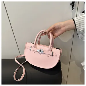 Dettaglio borsa a mano rosa a semicerchio con chiusura a scatto in metallo e trama in PU