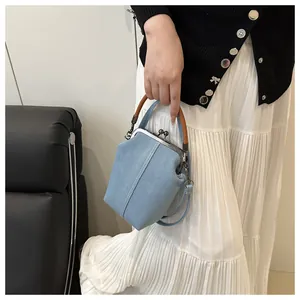 Detail der hellblauen Denim-Tasche mit Vintage-Metallverschluss und Holzgriff-Ring