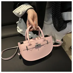 Dettaglio borsa a mano rosa a semicerchio in pelle con chiusura girevole e tracolla