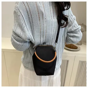 Model mit Vintage-Stofftasche in Schwarz mit braunem Rundgriff für den täglichen Gebrauch
