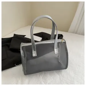 Silver mesh handbag detail featuring breathable fabric and metallic leather handle close-up