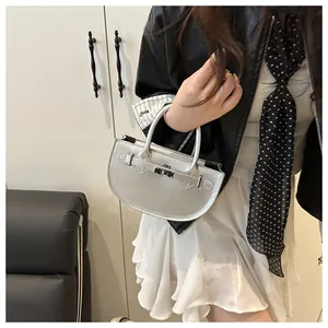 Dettaglio di una mini borsa a mezzaluna argento con finitura metallica e chiusura