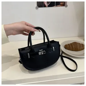 Dettaglio di una borsa a mezzaluna nera con chiusura a scatto in metallo argento e pelle