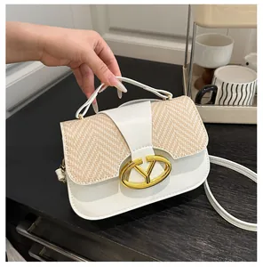Detail of elegant contrast stitching and golden V-shaped buckle on small crossbody bag