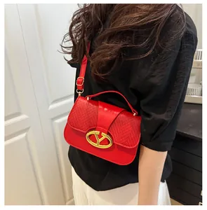 Fashionable red crossbody bag with mixed texture panels and gold metal buckle detail