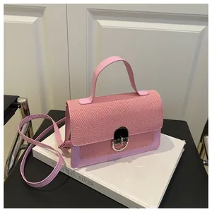 Detail of pink crossbody bag with textured weave flap and silver metal push-lock