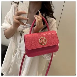 Détail du petit sac carré tressé rose rouge avec logo M doré et poignée supérieure