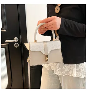 Detail von Glitzer-Patchwork, goldenem Schloss und schmalem Schultergurt der Handtasche