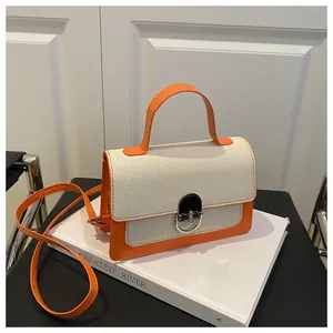 Detail of orange faux leather stitching and beige woven fabric on small square handbag