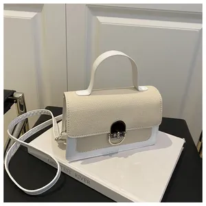Detail of the textured weave flap and metal twist lock on the white leather small square bag