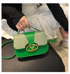 Detailed view of the green shoulder bag featuring chevron texture and a golden metal lock
